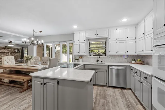 a kitchen with kitchen island granite countertop a sink cabinets and stainless steel appliances