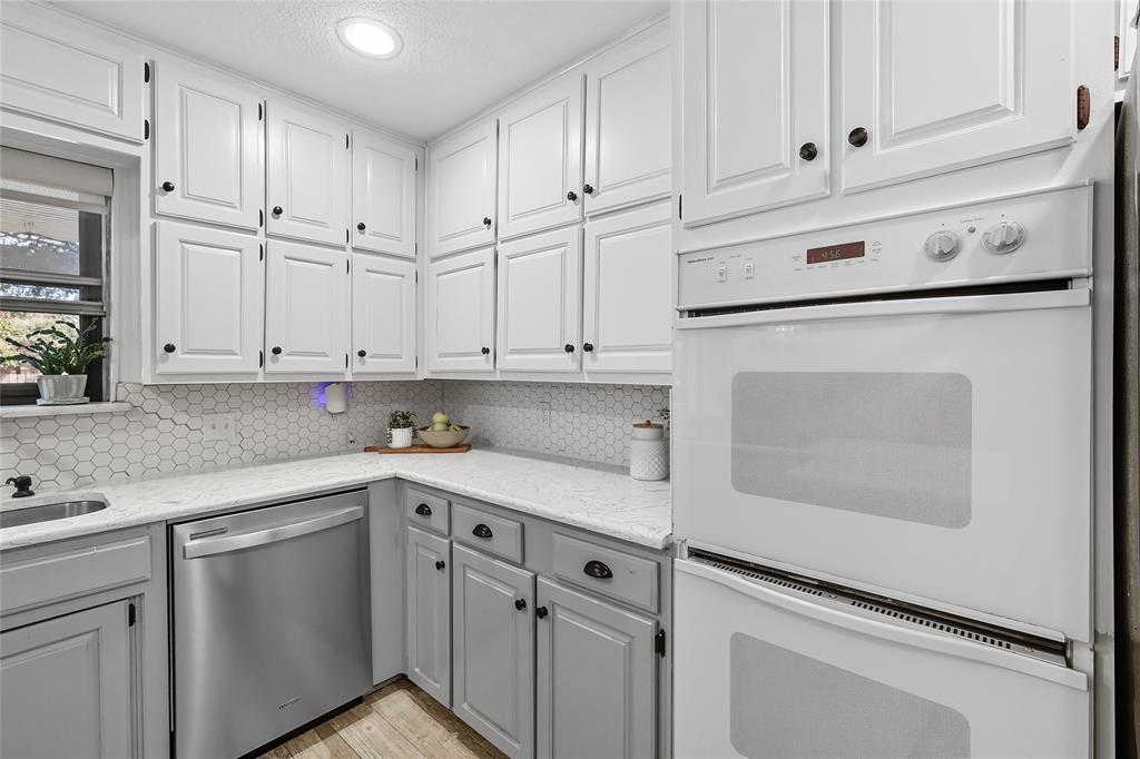 2908 Steve Drive Hurst, TX 76054 - Photo 18 of 40 a kitchen with granite countertop white cabinets and white appliances