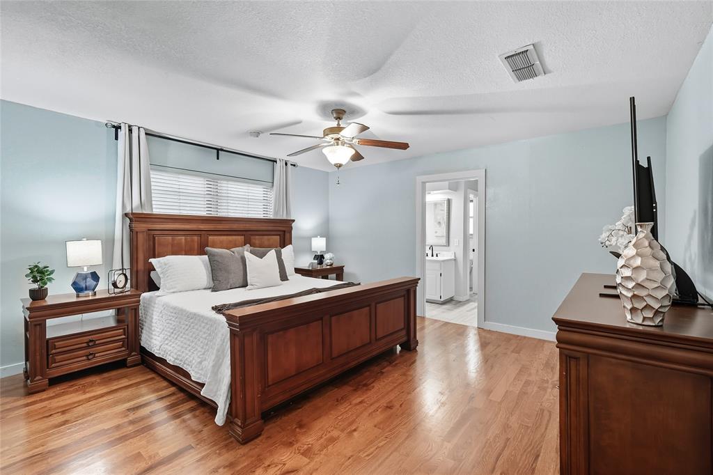 2908 Steve Drive Hurst, TX 76054 - Photo 22 of 40 a bedroom with a bed and a chandelier