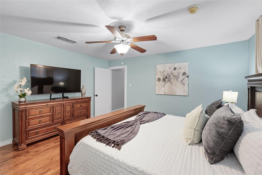 2908 Steve Drive Hurst, TX 76054 - Photo 23 of 40 a bedroom with a bed and a flat screen tv