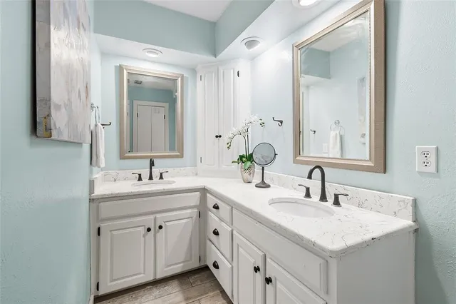 a bathroom with double sink and two mirror