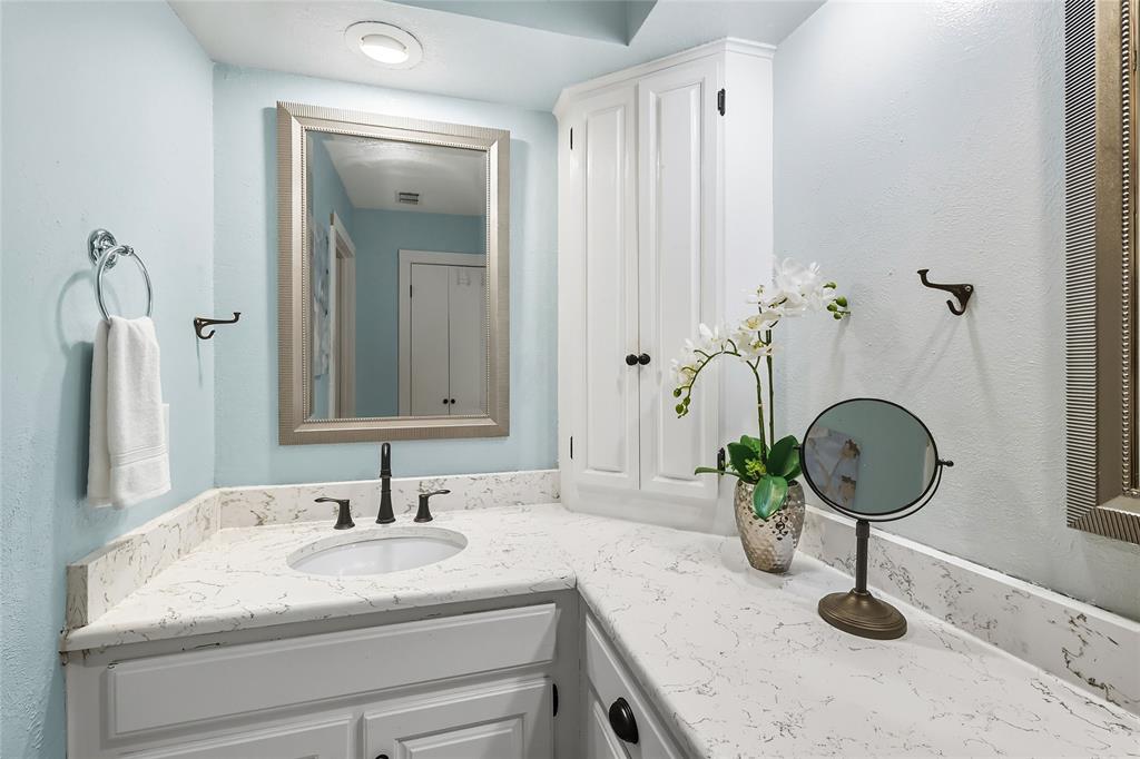 2908 Steve Drive Hurst, TX 76054 - Photo 26 of 40 a bathroom with a granite countertop sink a mirror and vanity