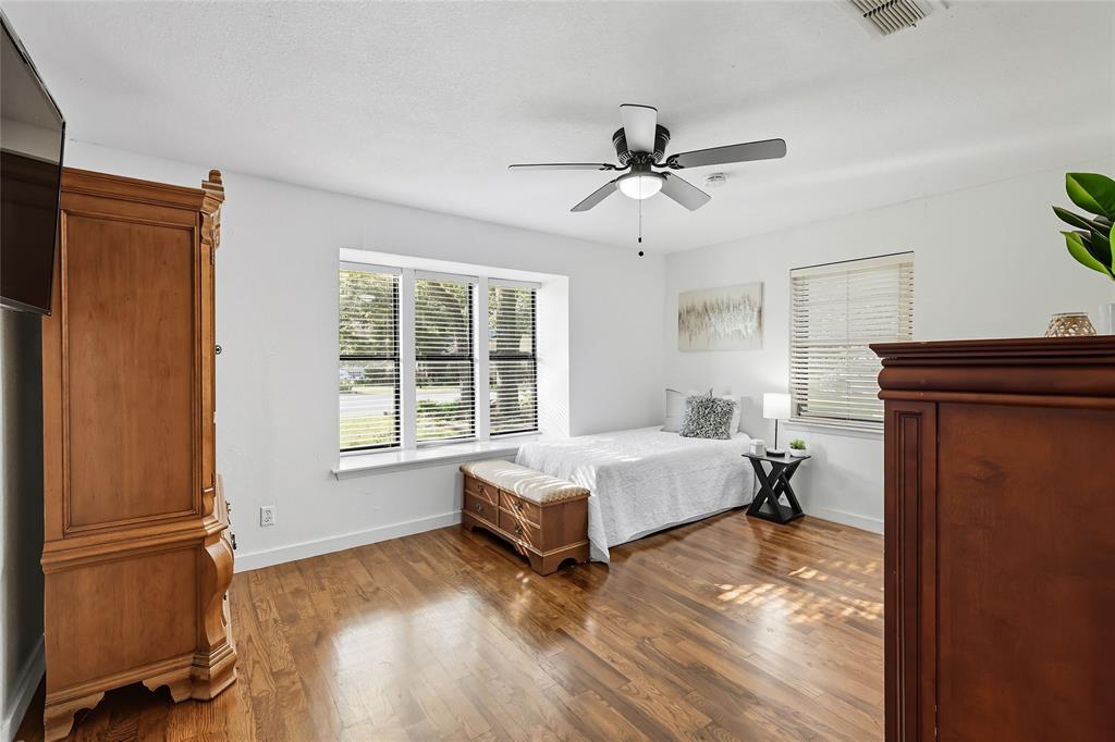2908 Steve Drive Hurst, TX 76054 - Photo 27 of 40 a spacious bedroom with a bed and wooden floor