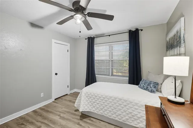 a bedroom with a bed and a lamp on a dresser