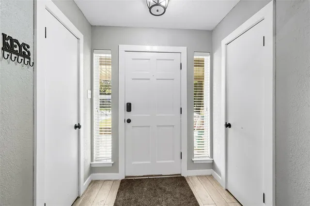 a view of a hallway with wooden floor and closet area