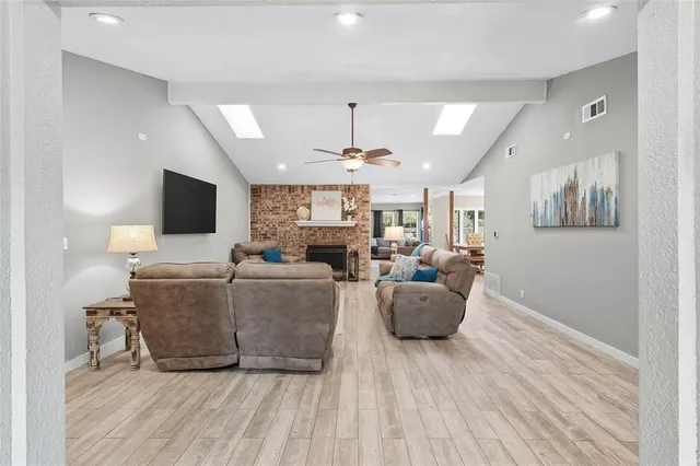 a living room with furniture a flat screen tv and a wooden floor