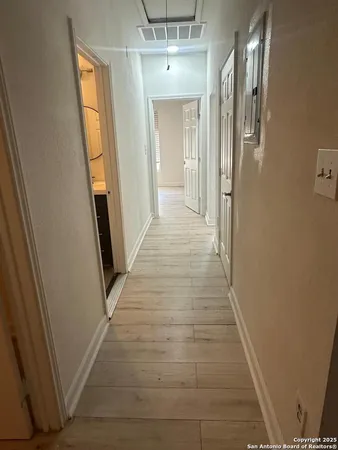 a view of a hallway with wooden floor and staircase