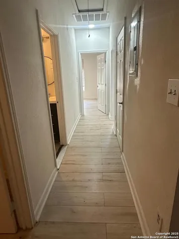 a view of a hallway with wooden floor and staircase