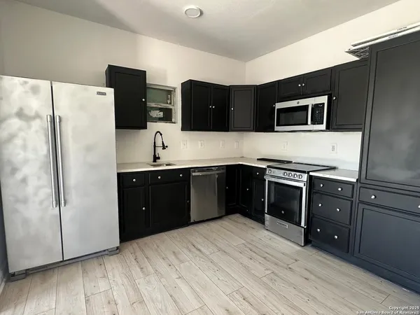 a kitchen with stainless steel appliances granite countertop a refrigerator and a sink