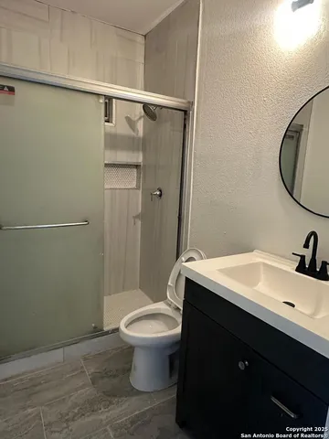 a bathroom with a sink a toilet and shower