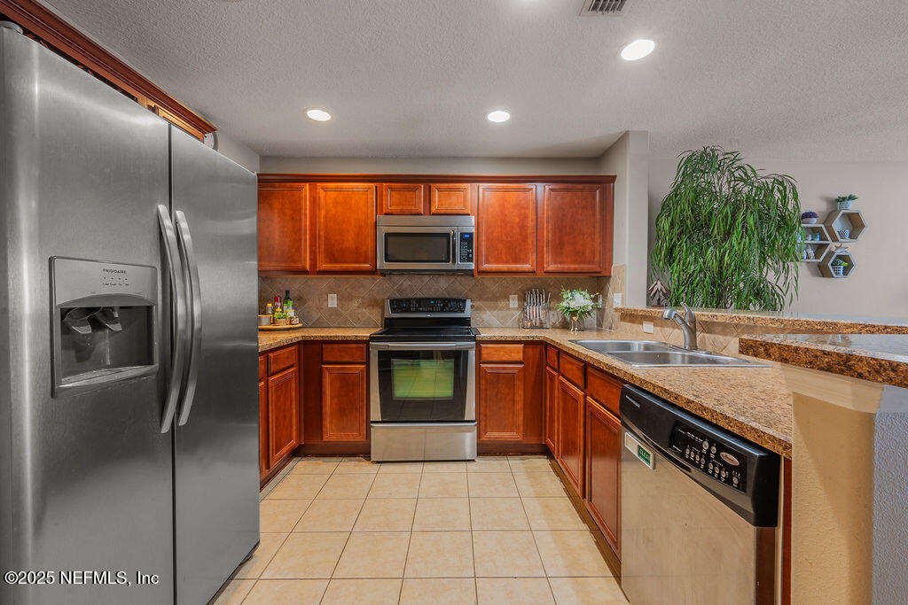 160 Crete Court St. Augustine, FL 32084 - Photo 11 of 33 a kitchen with stainless steel appliances granite countertop a refrigerator and a sink