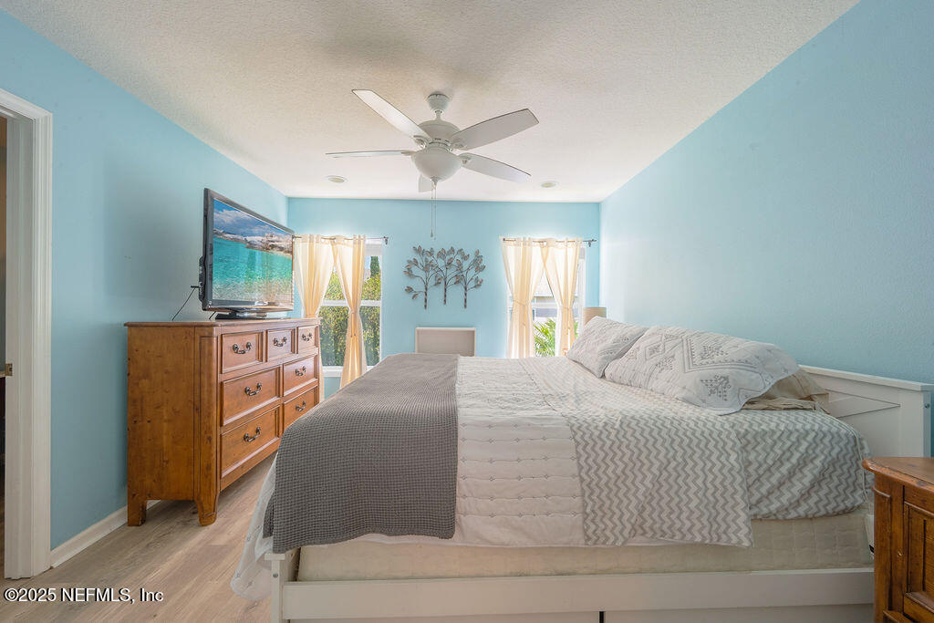 160 Crete Court St. Augustine, FL 32084 - Photo 14 of 33 a bedroom with a large bed and a chandelier