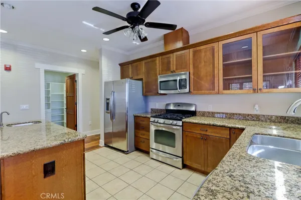 a kitchen with stainless steel appliances granite countertop a kitchen island a stove a sink dishwasher a dining table and chairs with wooden floor