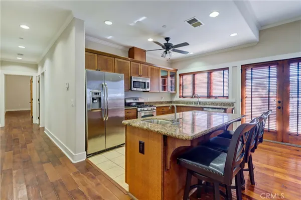 a large kitchen with stainless steel appliances granite countertop a large counter top a sink a stove and a refrigerator