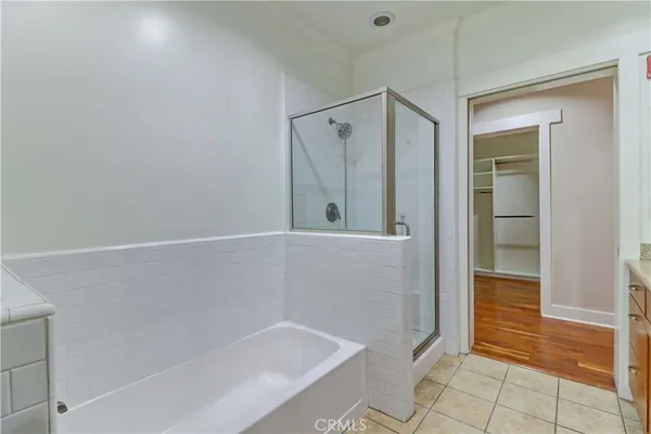 an empty room with wooden floor fireplace and windows