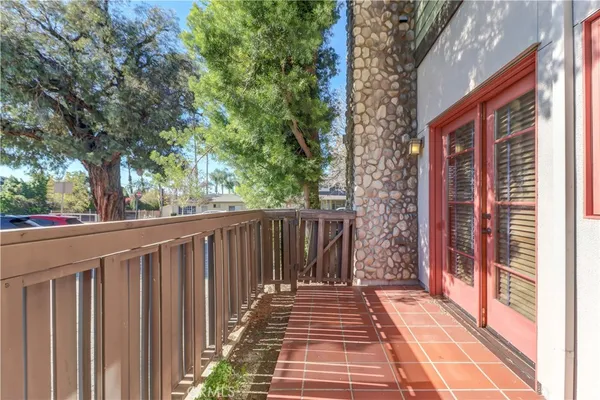 a view of a wooden balcony and trees