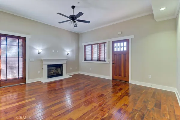 an empty room with windows fireplace and wooden floor