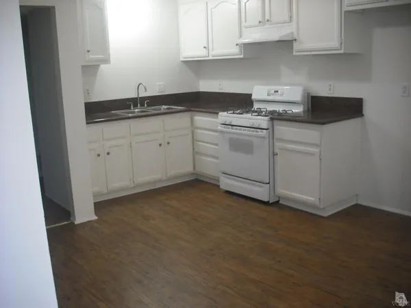 a kitchen with white cabinets and white appliances