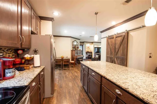 a kitchen with granite countertop stainless steel appliances and wooden floor