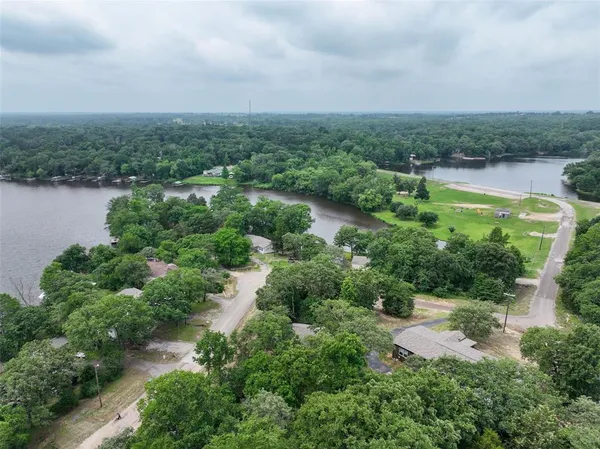 an aerial view of residential house with outdoor space and trees all around
