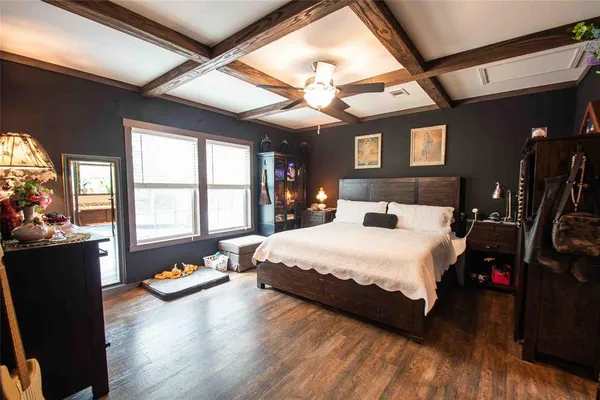 a bedroom with a bed a dresser next to a window