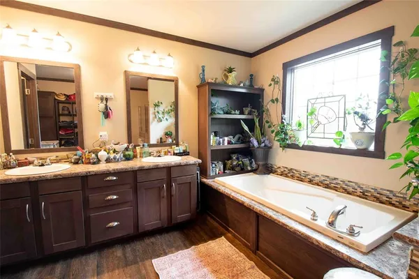 a spacious bathroom with a tub sink and mirror