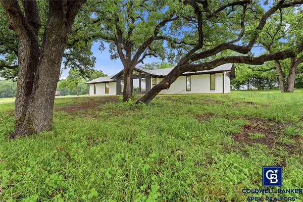 a house with green field in front of it
