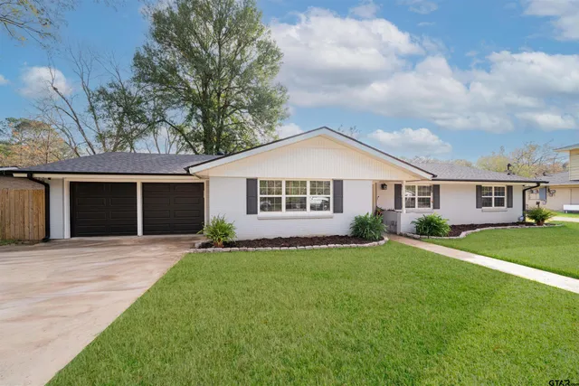 a front view of a house with a garden