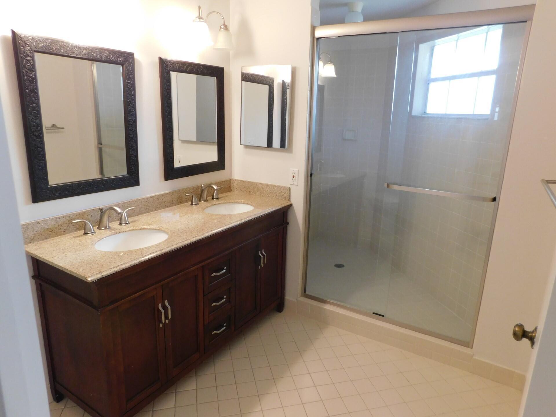 6630 Via Regina Boca Raton, FL 33433 - Photo 11 of 24 a bathroom with double sink and a mirror