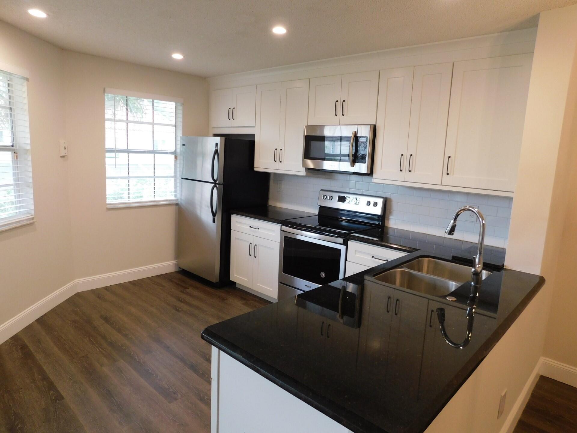 6630 Via Regina Boca Raton, FL 33433 - Photo 5 of 24 a kitchen with stainless steel appliances granite countertop a sink stove and refrigerator