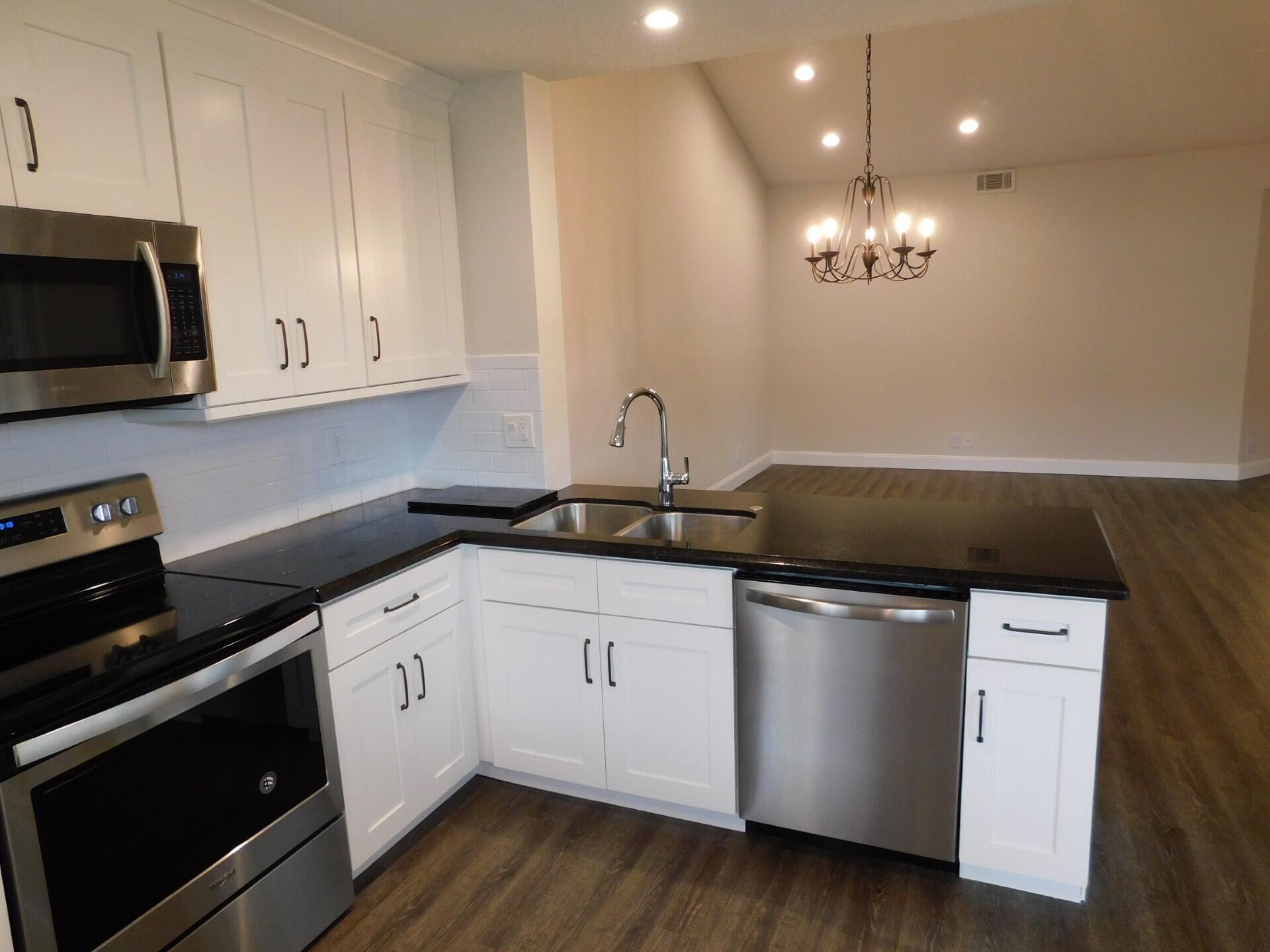 6630 Via Regina Boca Raton, FL 33433 - Photo 6 of 24 a kitchen with stainless steel appliances granite countertop a sink a stove a microwave and cabinets