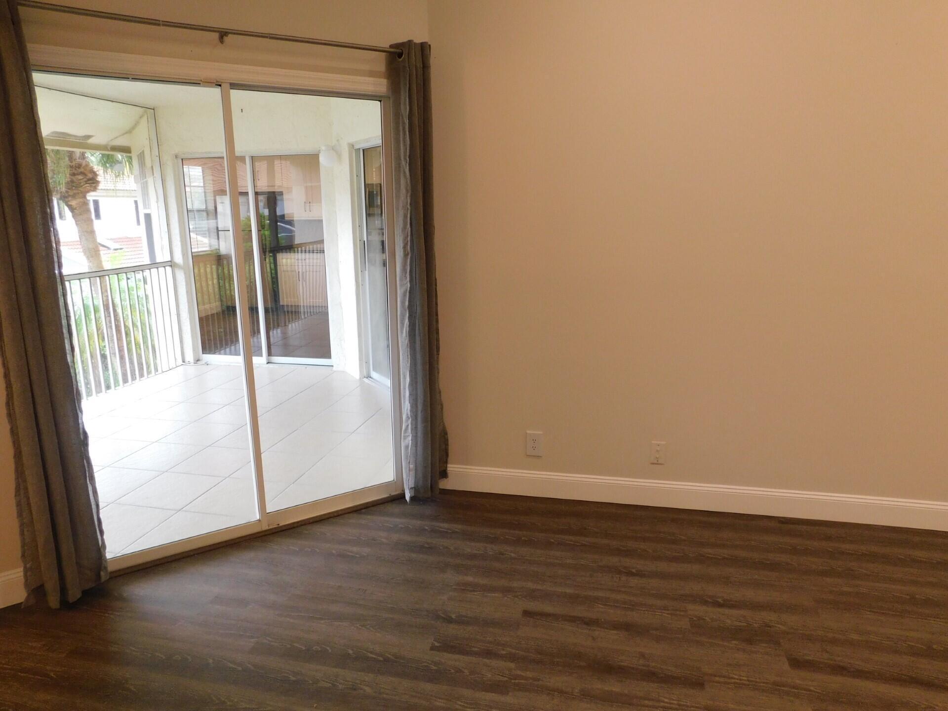 6630 Via Regina Boca Raton, FL 33433 - Photo 10 of 24 a view of an empty room with wooden floor and a window