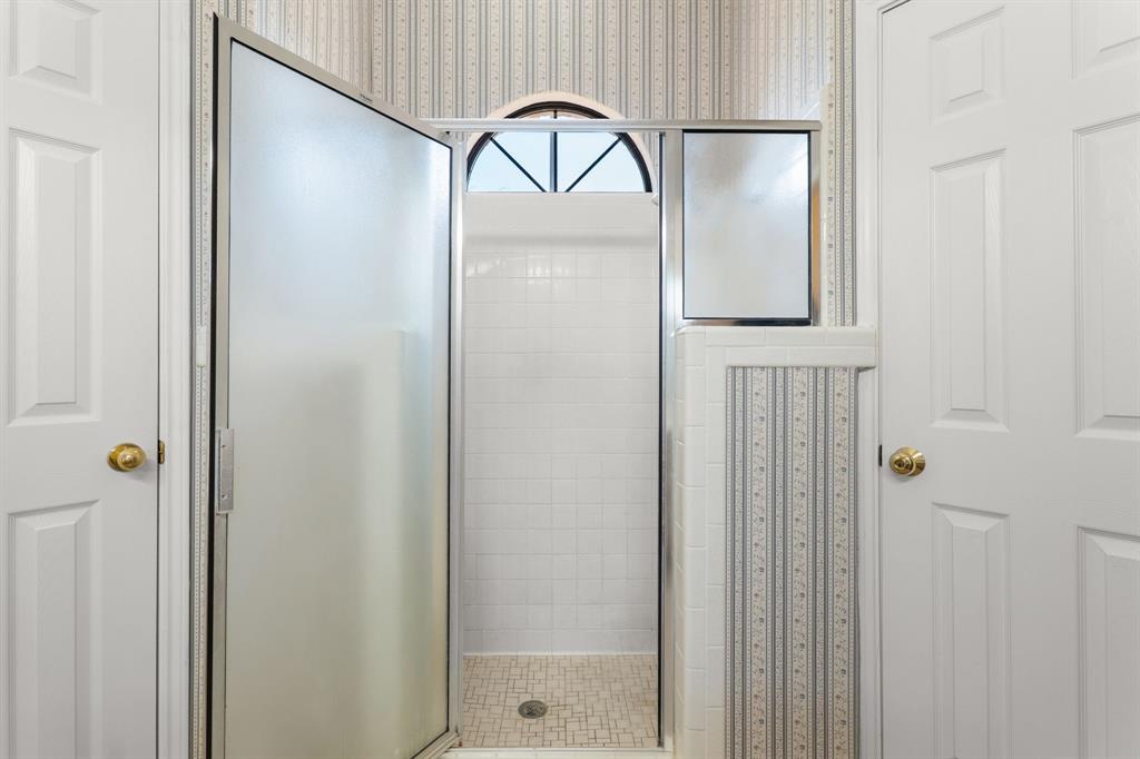 162 Warren Road Lorena, TX 76655 - Photo 24 of 39 Shower enclosure with frosted glass door, white subway tile surround, tile mosaic shower pan, and arched transom window