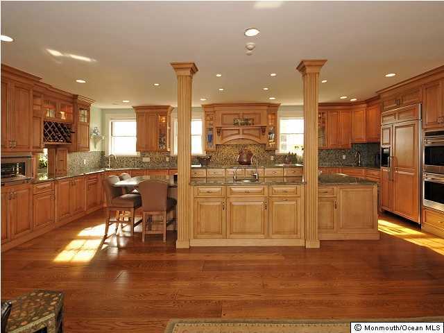 216 Seven Bridges Road Little Silver, NJ 07739 - Photo 15 of 21 a kitchen with stainless steel appliances kitchen island granite countertop a refrigerator a stove a sink and white cabinets with wooden floor