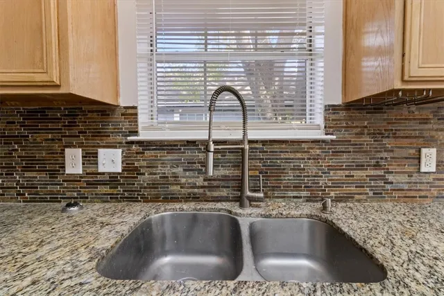 a kitchen with sink a window and cabinets
