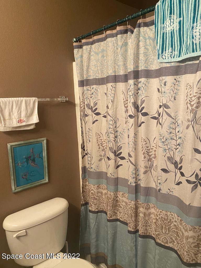 280 Wendover Road Southwest Palm Bay, FL 32908 - Photo 13 of 15 a bathroom with a toilet and a shower curtain