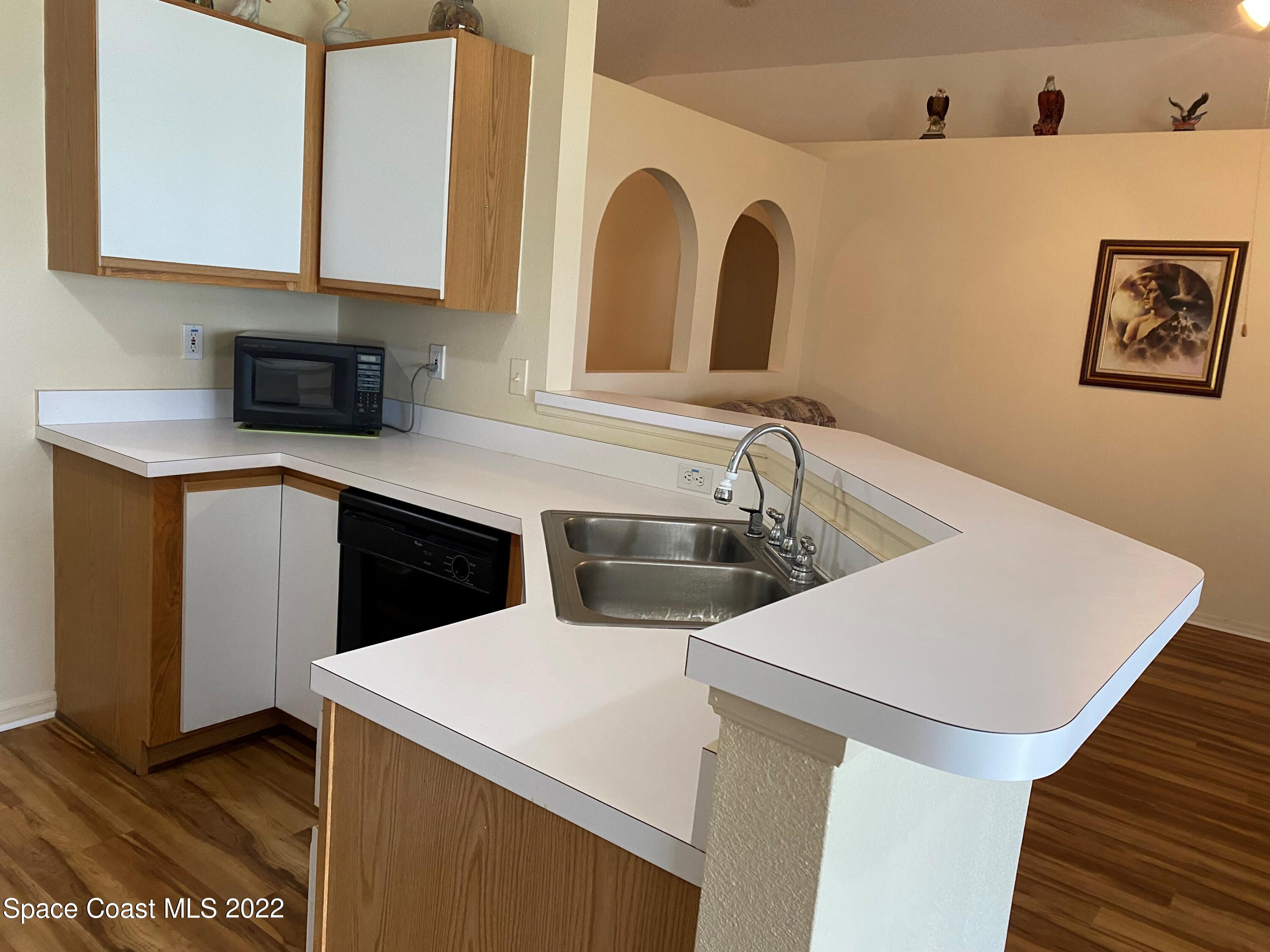 280 Wendover Road Southwest Palm Bay, FL 32908 - Photo 6 of 15 a kitchen with a sink a refrigerator and cabinets