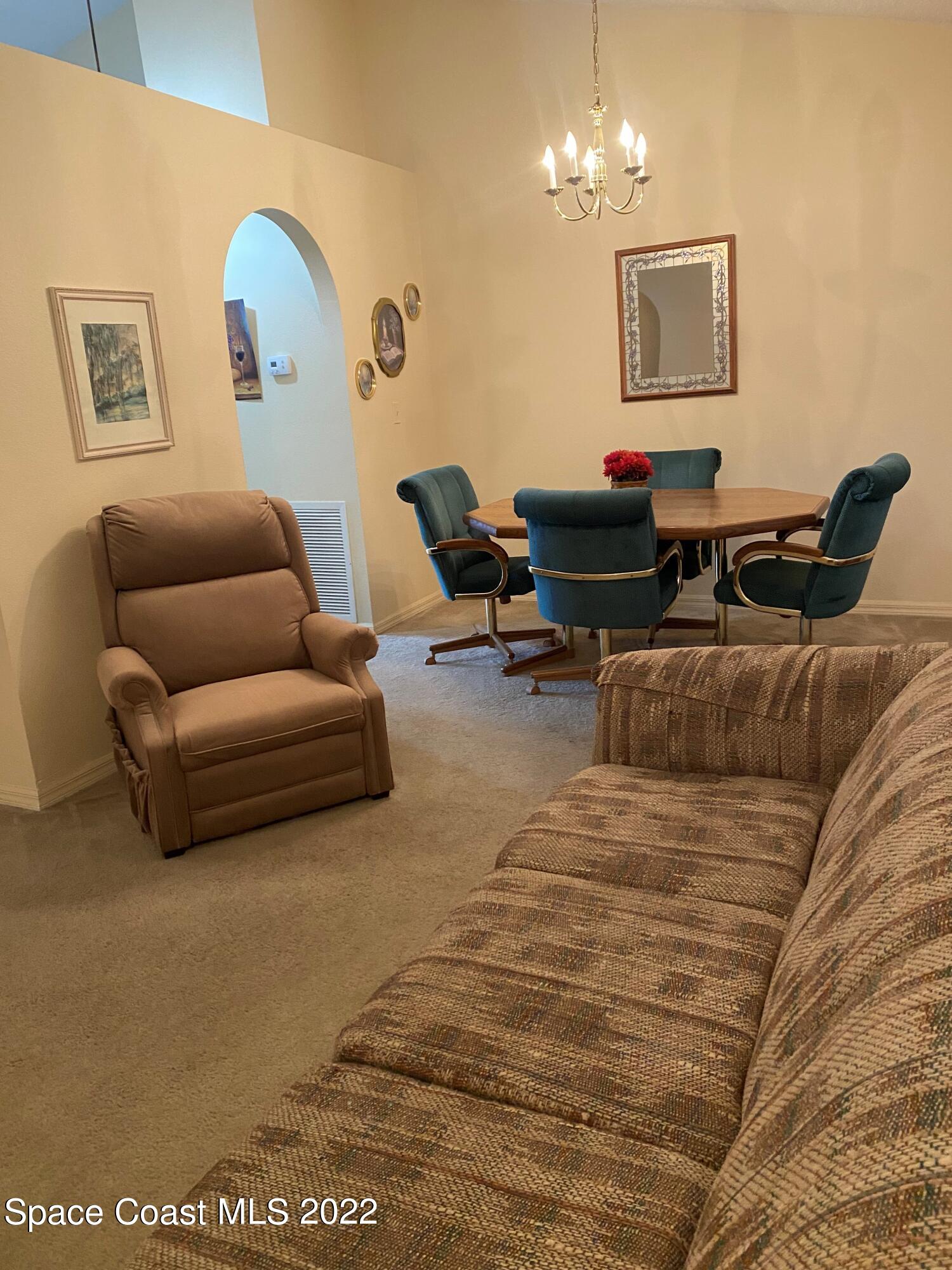 280 Wendover Road Southwest Palm Bay, FL 32908 - Photo 10 of 15 a living room with furniture a lamp and a chandelier