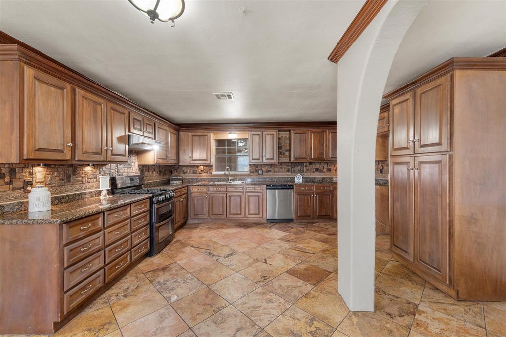 3433 West Tours Road West, TX 76691 - Photo 11 of 40 a kitchen with stainless steel appliances granite countertop a refrigerator sink and cabinets