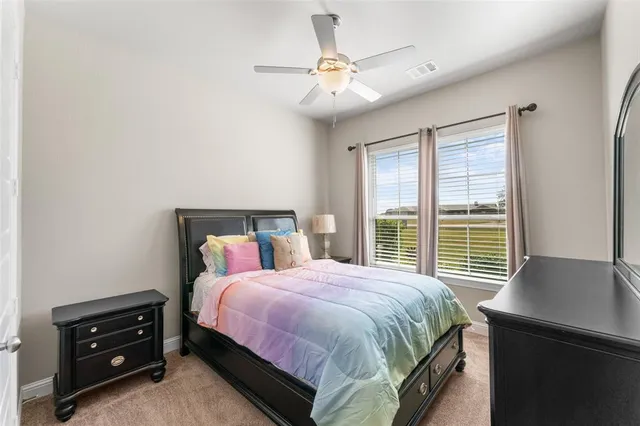 a bedroom with a bed and a ceiling fan