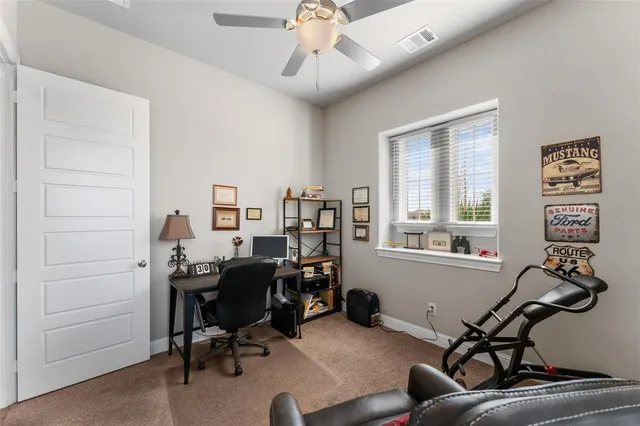a view of a workspace with furniture and a window