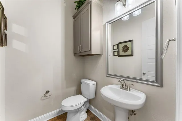 a bathroom with a sink toilet and a mirror