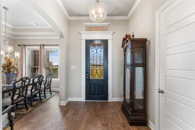 wooden floor in an entryway with a dining room view