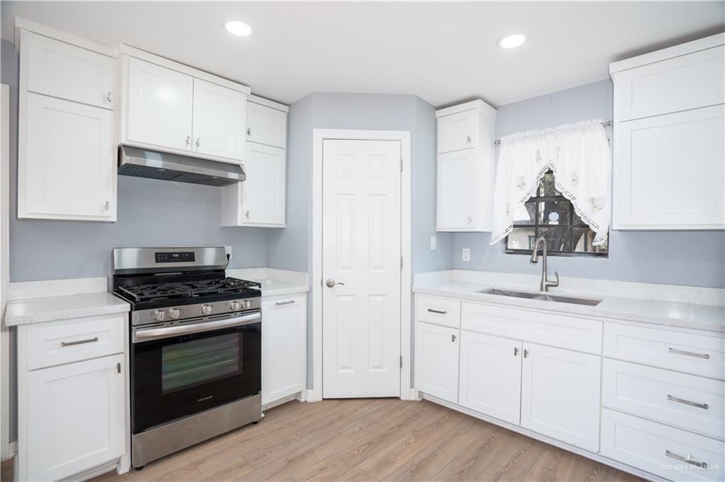 212 North Street Mission, TX 78572 - Photo 7 of 26 a kitchen with appliances cabinets and a wooden floor