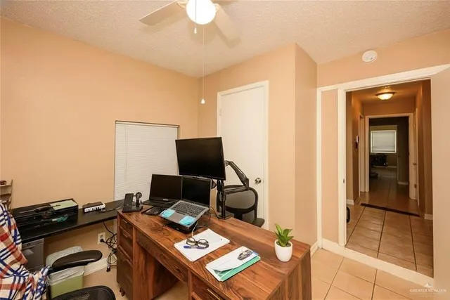 a view of a workspace with furniture and a window