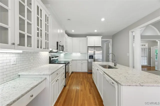 a large kitchen with stainless steel appliances granite countertop a lot of counter space and wooden floors