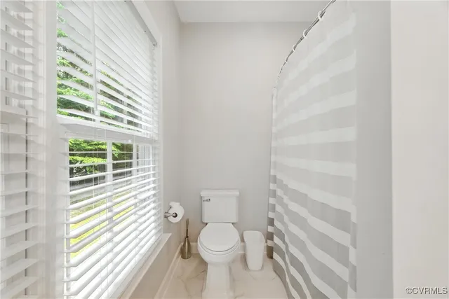 a bathroom with a toilet a sink and a window