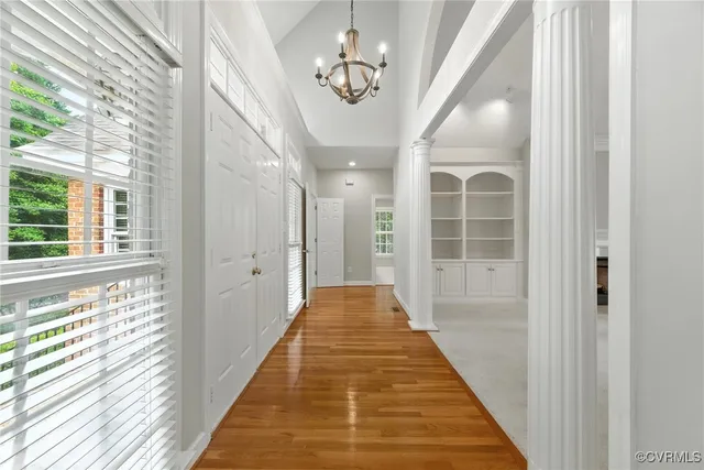 a view of a hallway with wooden floor and windows