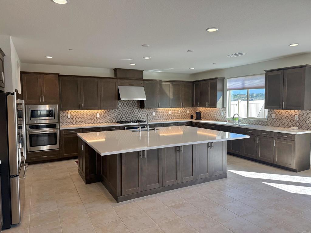 39529 Dayspring Way Temecula, CA 92591 - Photo 7 of 49 a kitchen with stainless steel appliances granite countertop a sink stove and refrigerator