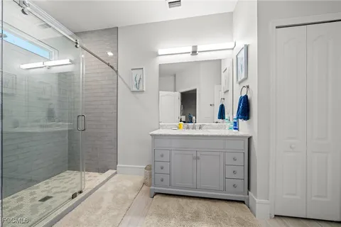 a bathroom with a double vanity sink mirror and shower